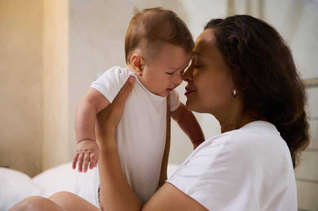 A mother lovingly holds her baby close, gently touching foreheads in a quiet moment of connection—reflecting the emotional bond and support needed when navigating bottle feeding or bottle refusal challenges.