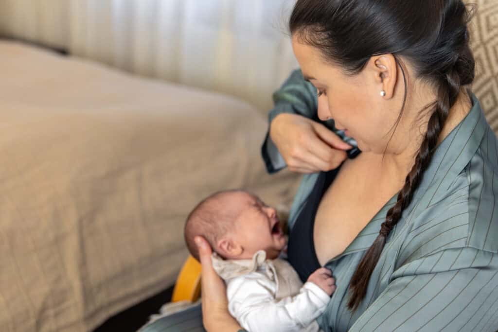 A mother and bay frustrated at trying to breastfeed but having latching and positioning issues.